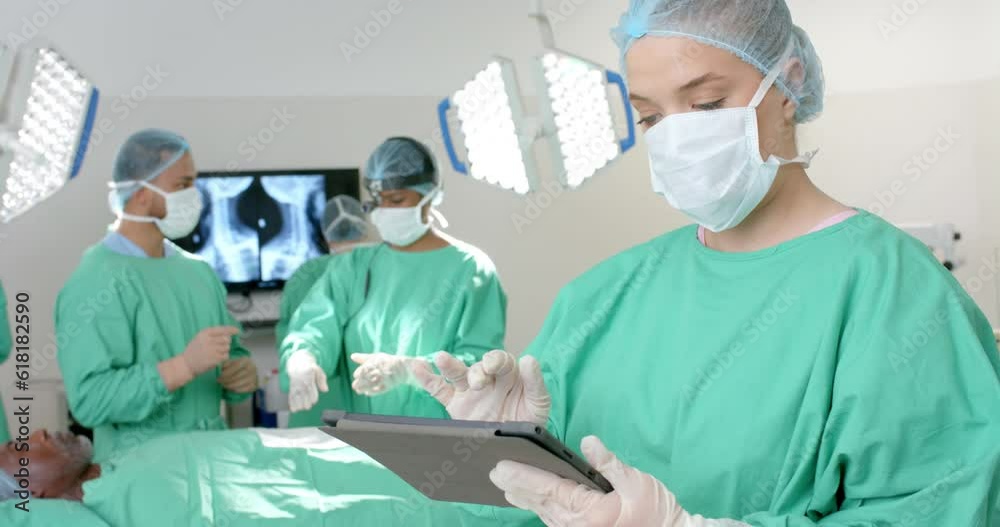 Portrait of caucasian male surgeon wearing surgical gown, using tablet, slow motion Portrait of caucasian male surgeon wearing surgical gown, using tablet, slow motion