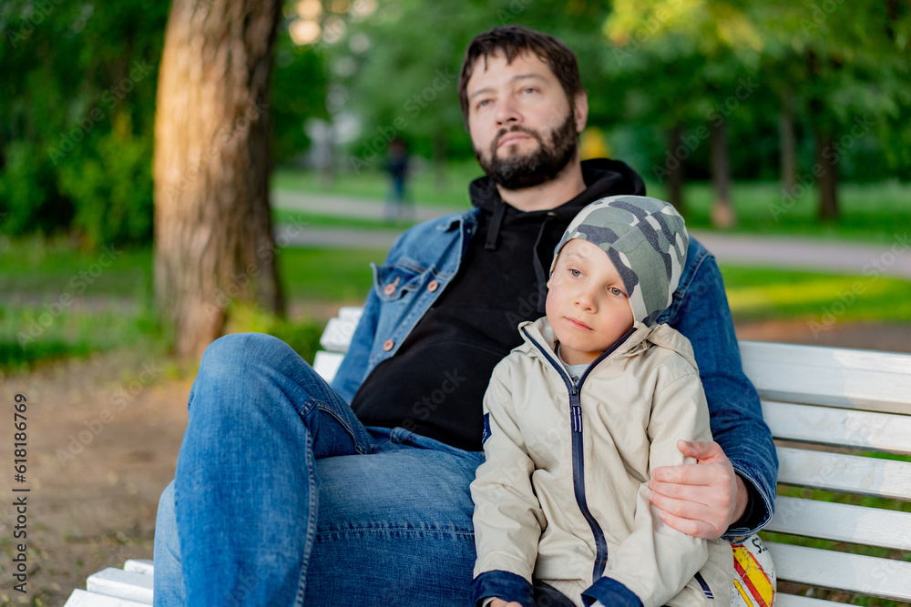 Caucasian bearded man with his little son in park. Image with selective focus