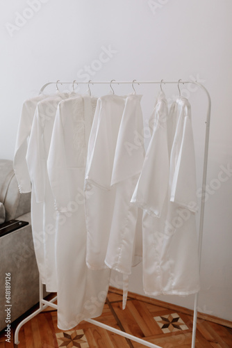 white identical women's outfit on a hanger. Women's robes. A girl's evening in the same outfit