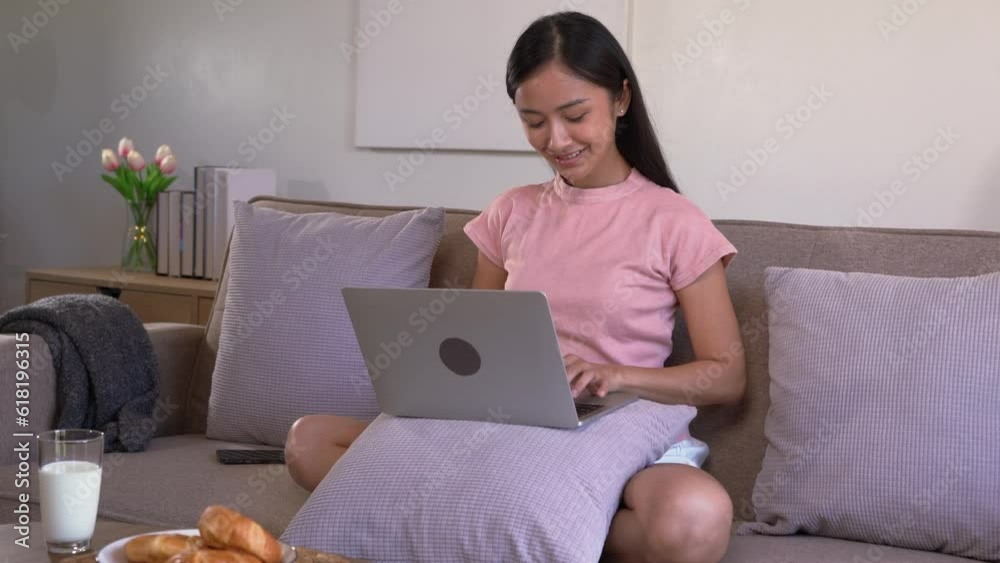 Asian woman working and researching online on labtop and relax lifestyle while sitting on sofa at home. Asian woman working and researching online on labtop and relax lifestyle while sitting on sofa at home.