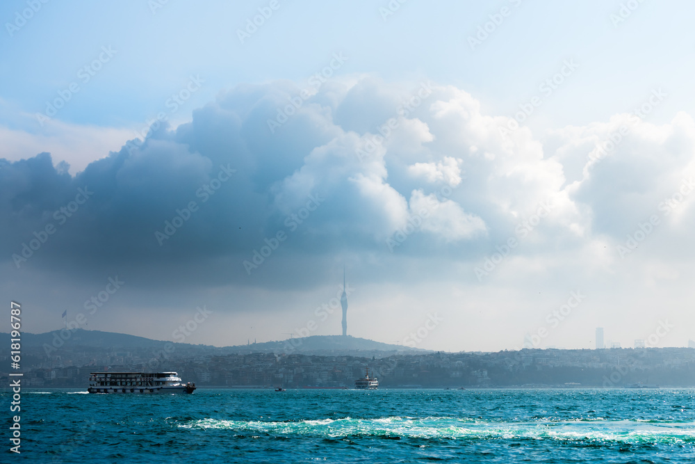 Tourist ship on the Boshporus in Istanbul, Turkey. Big cloud over Asian part of Istanbel