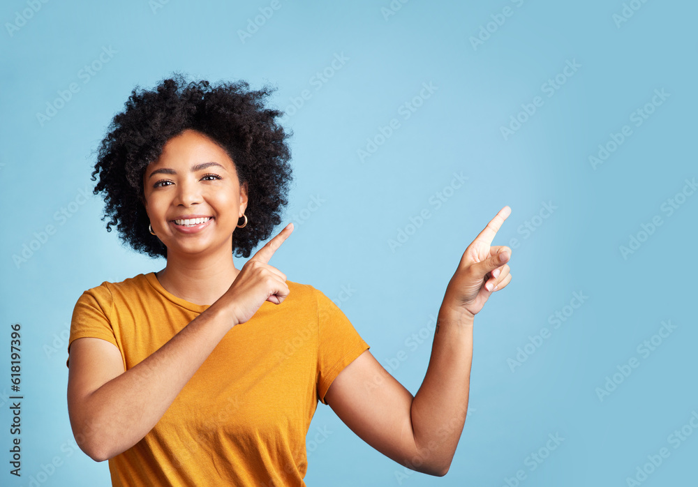 Happy, portrait of woman pointing and against blue background for giveaway. Direction or marketing, advertising or product placement and female person pose with hand gesture in studio backdrop Happy, portrait of woman pointing and against blue background for giveaway. Direction or marketing, advertising or product placement and female person pose with hand gesture in studio backdrop