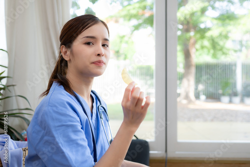 Free Download A female nurse is eating a fried potatoes of bread in her office. - GFXLoad