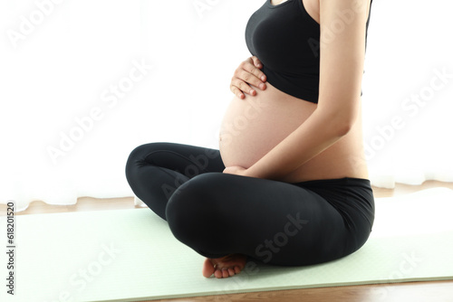 임신한 여성이 거실에서 명상을 하고있다