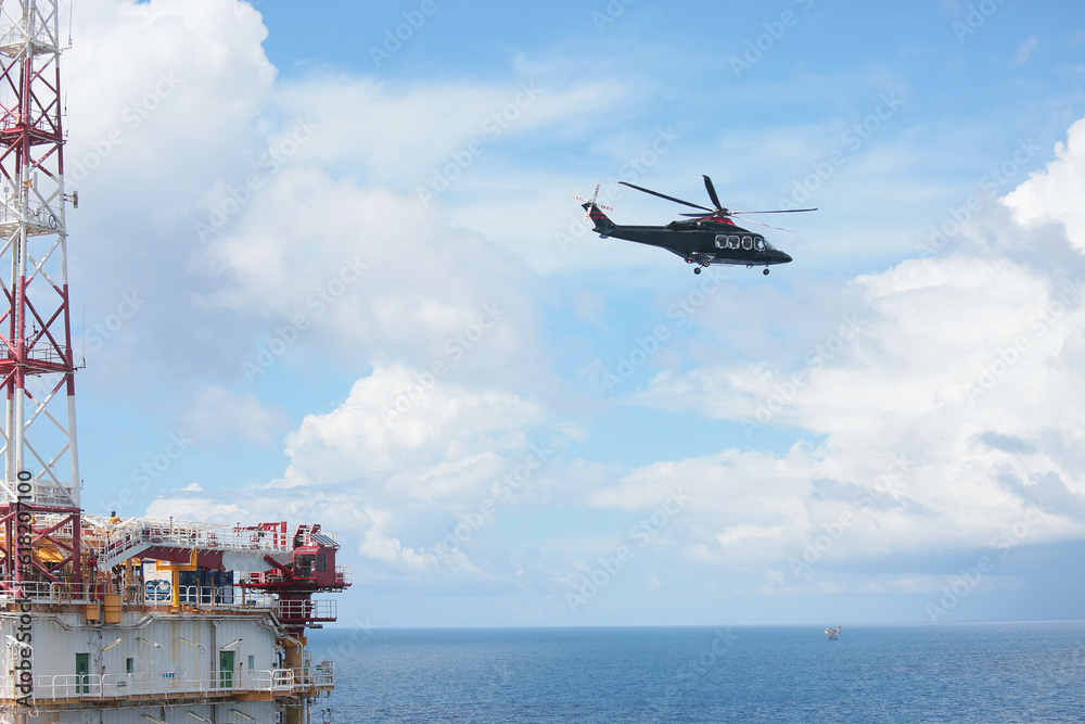 Fototapeta premium Helicopter Landing Officer communicating with pilot and copilot for service on ground and support as the pilot required. The helicopter landing on the deck in oil and gas platform