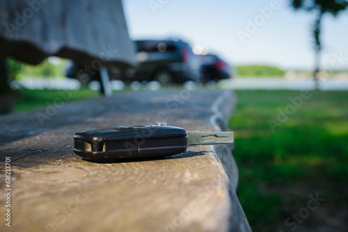 Abandoned,Forgotten car key on a wooden plank on a bench at summer park.Selective focus.
