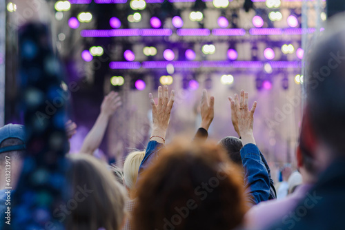 A festival crowd raising their hands.Party people at a concert.Rear view.