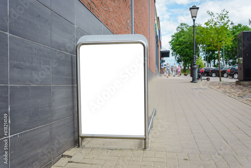 Blank street billboard white mockup upnear entrnace of shopping center in downtown.Summer day. photo
