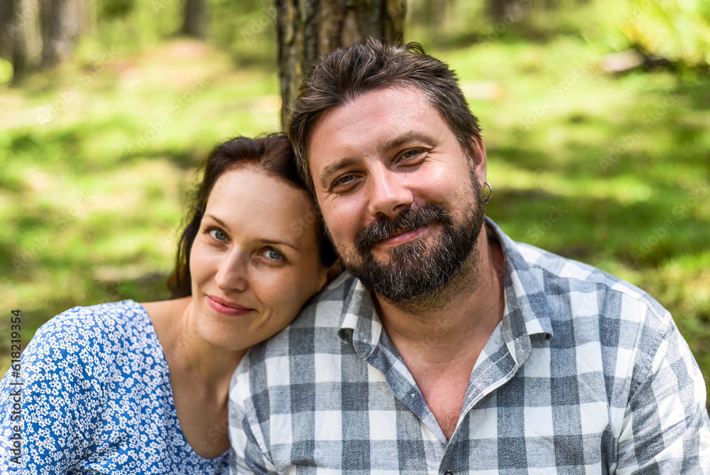 Portrait of young married couple sitting in the forest on a sunny day Portrait of young married couple sitting in the forest on a sunny day