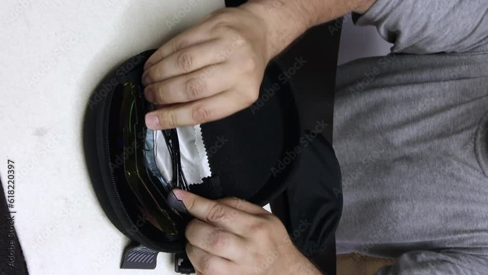 A man puts lenses for sunglasses in a protective box. Glasses with interchangeable colored lenses. A blogger makes a review of sunglasses. vertical video A man puts lenses for sunglasses in a protective box. Glasses with interchangeable colored lenses. A blogger makes a review of sunglasses. vertical video