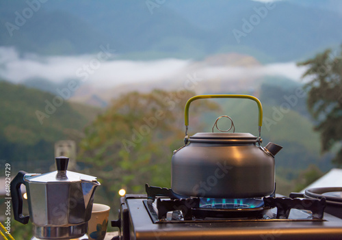 Fotografia Outdoor kitchen equipment camp fire and brewing tea pot moka coffee drip cup,wit