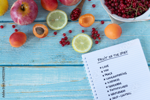 Картината върху платно Fruit of the Spirit handwritten words in notebook from Galatians Bible Book on wooden table with fresh colorful fruit