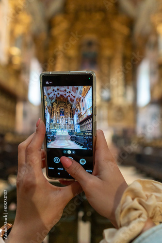 A Girl is using a phone to take a picture inside the cathedral