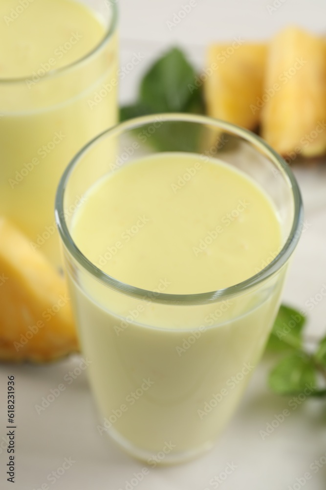 Tasty pineapple smoothie on white table, closeup Tasty pineapple smoothie on white table, closeup