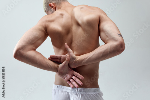 Cropped image of beautiful, strong, muscular, relief male's back against grey studio background. Caring after health. Concept of male natural beauty, body care, health, sport, fashion, ad photo