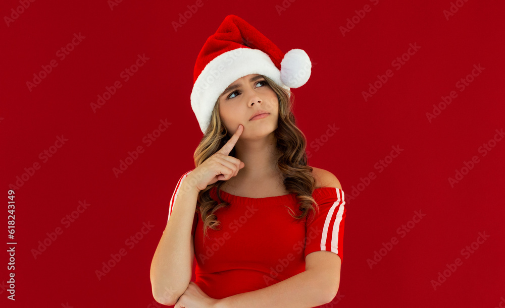 Photo of funny pretty lady celebrate winter holidays dreamy look empty space think family party hand on chin x-mas concept wear santa cap red isolated red color background Photo of funny pretty lady celebrate winter holidays dreamy look empty space think family party hand on chin x-mas concept wear santa cap red isolated red color background