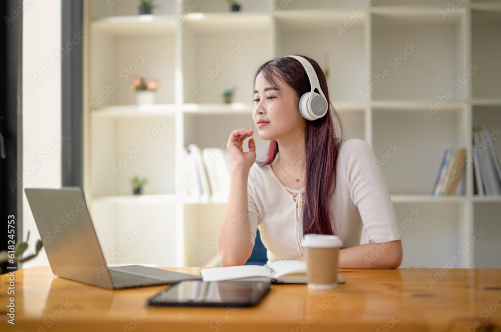 Portrait of teenage smiling girl using a laptop and wearing headphones, study online via video conferencing, enjoy with movie. Portrait of teenage smiling girl using a laptop and wearing headphones, study online via video conferencing, enjoy with movie.