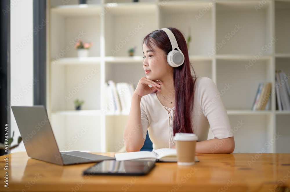 Portrait of teenage smiling girl using a laptop and wearing headphones, study online via video conferencing, enjoy with movie. Portrait of teenage smiling girl using a laptop and wearing headphones, study online via video conferencing, enjoy with movie.