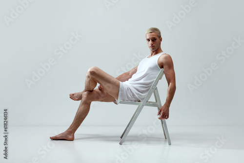 Comfort look. Young handsome man with muscular body posing in underwear and singlet against grey studio background. Concept of male natural beauty, body care, health, sport, fashion, ad photo