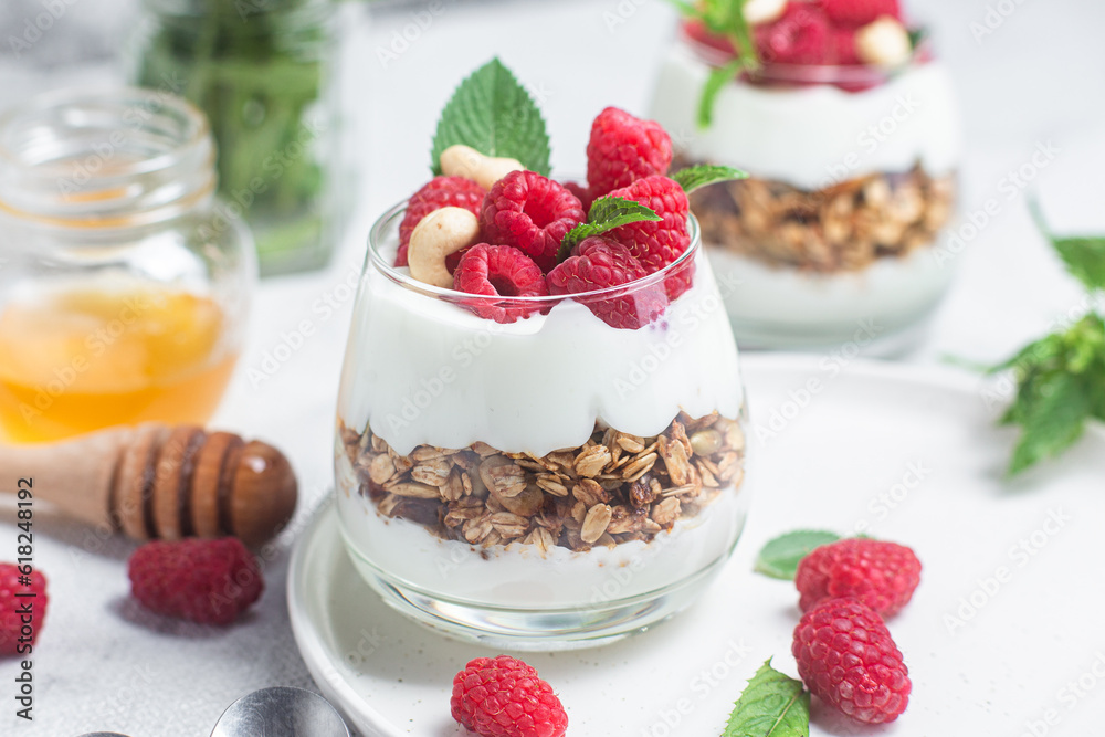 Granola with yogurt and raspberries in a glass Granola with yogurt and raspberries in a glass