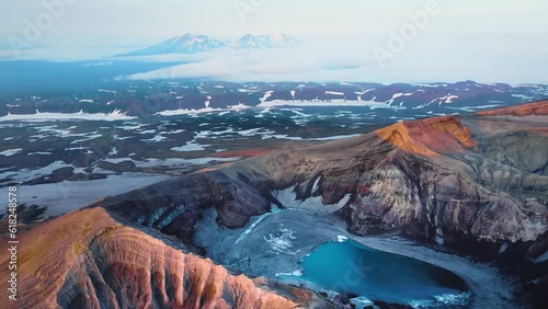 Gorely volcano crater with blue lake in Kamchatka, Russia. Aerial view. Mountains and volcanoes with clouds at sunrise. Beautiful summer landscape
 photo