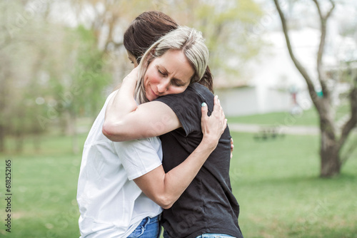 Canvas Print woman comforting her sad friend who is complaining in the park