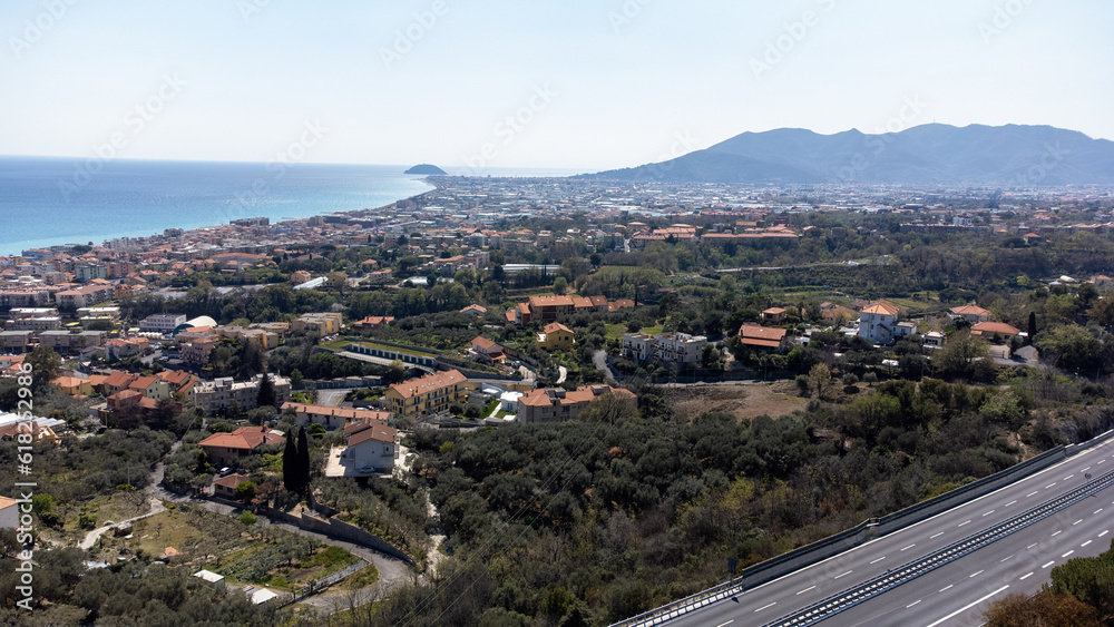 Drone footage looking over an Italian city towards the Mediterranean Sea in spring