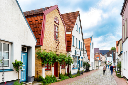 Gable Houses with high roses on a house wall in the fishing village Holm in Schleswig, Germany