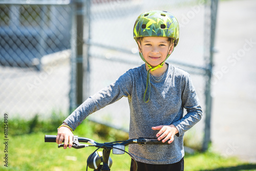 child having fun outdoors driving bike for children on playground