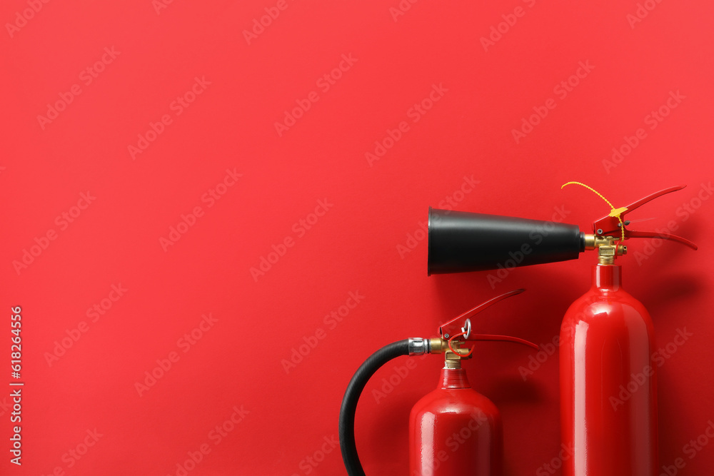 Fire extinguishers on red background, flat lay. Space for text Fire extinguishers on red background, flat lay. Space for text