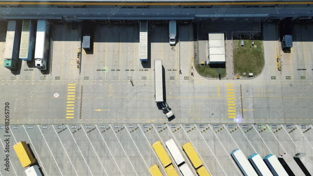 Truck is parked for unloading at the logistics center. Industrial area with commercial warehouses. Cargo terminal, distribution center and semi-trailers. Transportation, distribution, shipping. 4k Truck is parked for unloading at the logistics center. Industrial area with commercial warehouses. Cargo terminal, distribution center and semi-trailers. Transportation, distribution, shipping. 4k