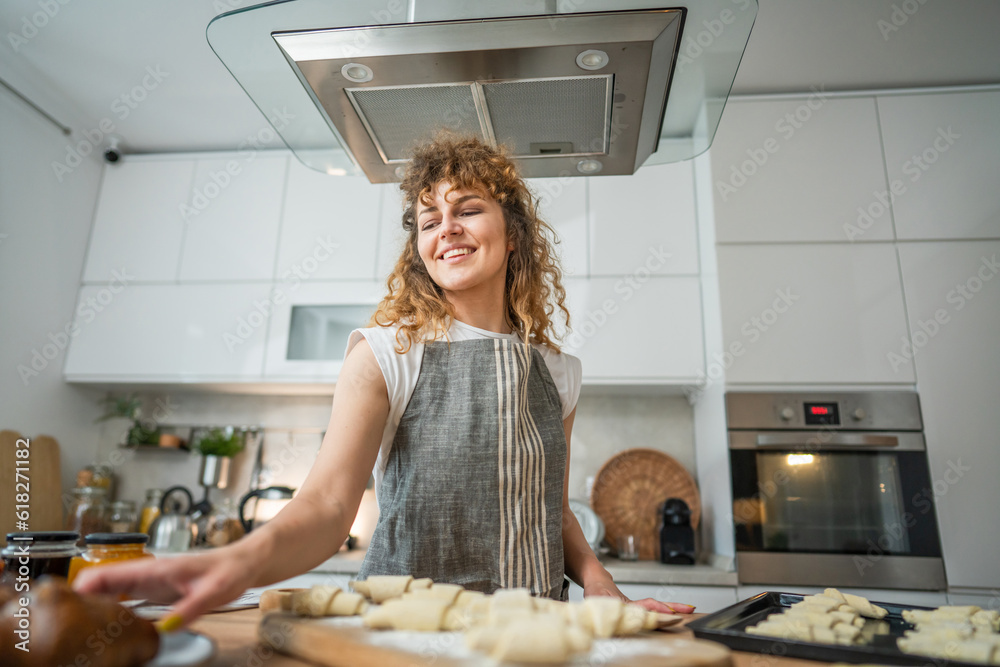 Obraz premium One happy young adult caucasian woman wear apron cook in the kitchen
