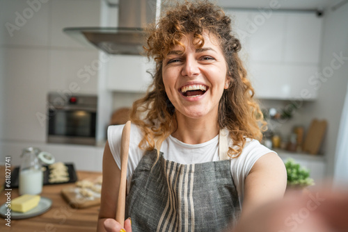 One happy young adult caucasian woman wear apron in the kitchen smile
