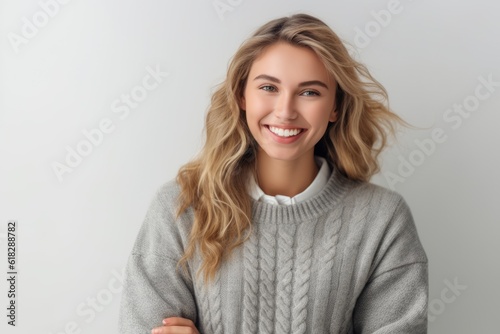Portrait of a beautiful young woman with blond hair in a gray sweater.