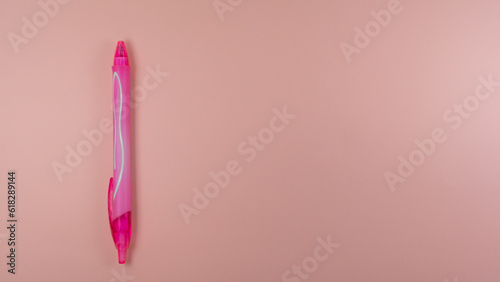 a pink black pen lies on a pink background. view from above