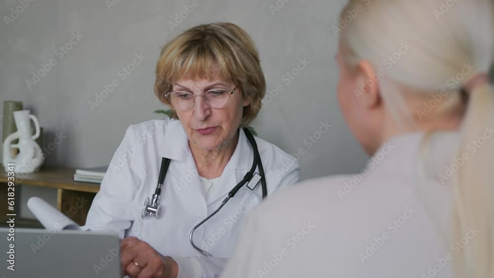 A professional doctor, an old woman, communicates with a patient in her office and reports the joyful news after the examination. Great news in medicine. The doctor tells the patient good news. 4k A professional doctor, an old woman, communicates with a patient in her office and reports the joyful news after the examination. Great news in medicine. The doctor tells the patient good news. 4k