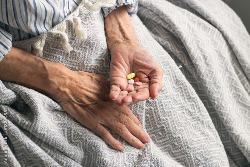 Old woman holding medicine and taking vitamins to heal. Colorful pills in old woman hand. Care for the health of old people Old woman holding medicine and taking vitamins to heal. Colorful pills in old woman hand. Care for the health of old people