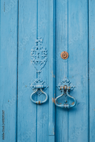  Light blue wooden door with vintage style designs in a small village of Europe © Adrinson