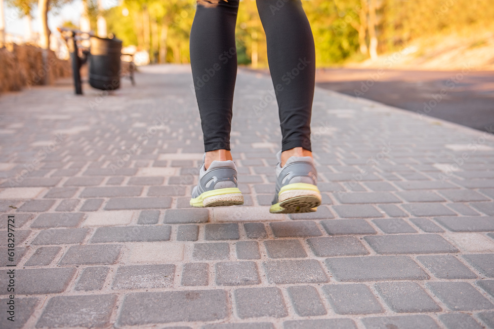 Close-up of runners sneakers of an athlete running marathon. Womens legs are engaged in jogging Close-up of runners sneakers of an athlete running marathon. Womens legs are engaged in jogging