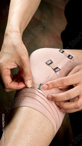 Self-Care Tutorial: Close-Up of a Middle-Aged Woman Skillfully Applying a Bandage on Her Knee in 4K Resolution