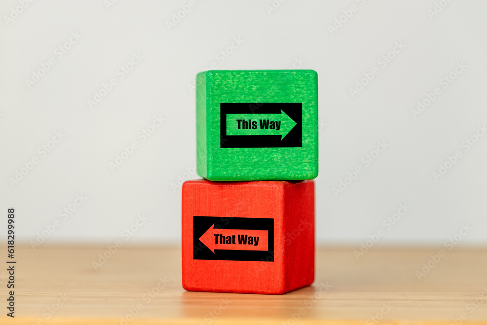 Making the right decisions, green and red wooden block with arrows in opposite directions. Text this way and that, Concept, Difficult decision, Business direction, Life decision Making the right decisions, green and red wooden block with arrows in opposite directions. Text this way and that, Concept, Difficult decision, Business direction, Life decision