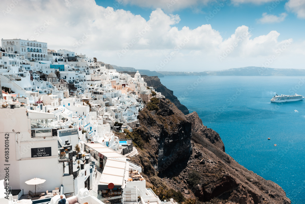 magical and sun covered city of thira, ideal for vacation and travel during hot summer days, on the horizon the sea and beautiful roofs of houses, travel and relaxation in greece,white and blue 