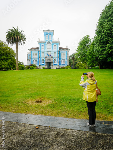 young woman contemplating a nice building in the town of Colombres in Asturias photo