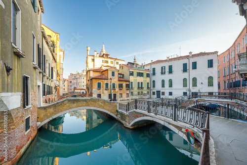 Canal with stone bridges and historic buildings in Venice, Italy, Europe.