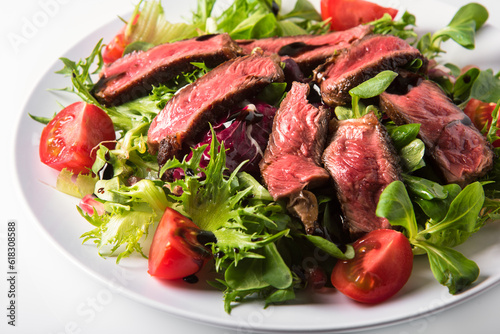 Pieces of beef with fresh lettuce and cherry tomatoes, dressed with olive oil and balsamic cream.