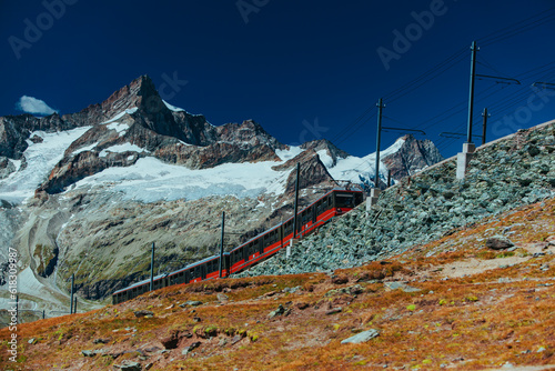 Red train in high Alps mountains