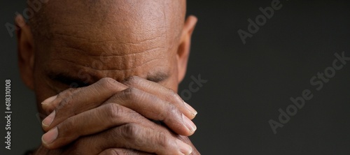 man praying to god with hands together Caribbean man praying stock photo	