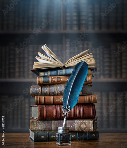Old books ,quill pen and vintage inkwell on wooden desk in old library. Ancient books historical background. Retro style. Conceptual background on history, education, literature topics..