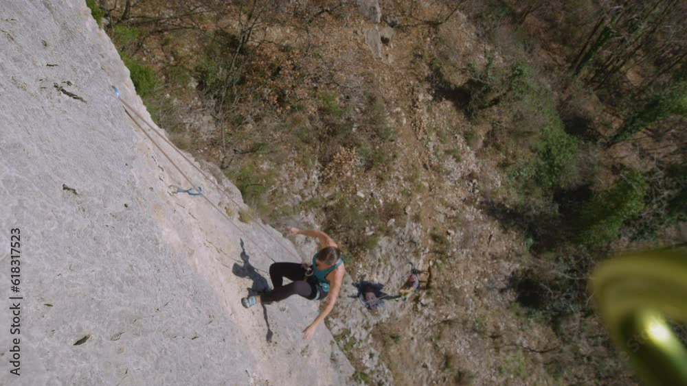 CLOSE UP: Female climber falls while climbing rocky wall after losing her grip. She was lead climbing and attentive belayer braced the catch. Adrenaline sport on limestone walls of sunny Karst Edge. CLOSE UP: Female climber falls while climbing rocky wall after losing her grip. She was lead climbing and attentive belayer braced the catch. Adrenaline sport on limestone walls of sunny Karst Edge.