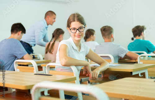 Portrait of diligent teenager girl high school student looking at camera during lesson in college